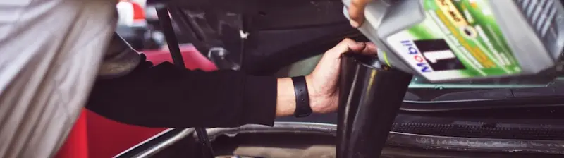 An appraiser checking under the hood of a car