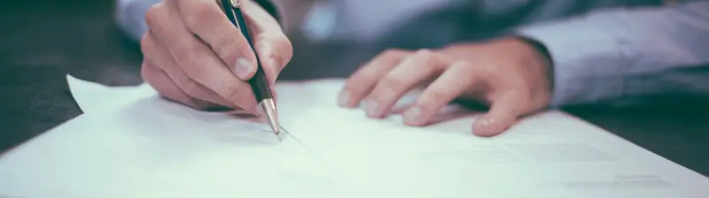 Signing loan paperwork at a desk