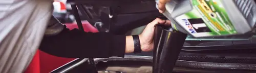 An appraiser checking under the hood of a car